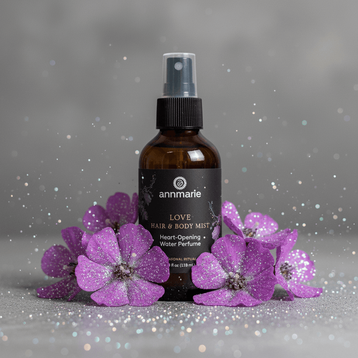 Brown bottle of 'annmarie' Love Hair & Body Mist with purple flowers on a gray background
