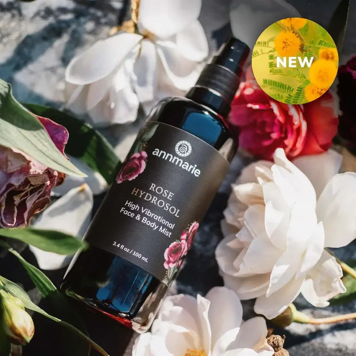 Rose Hydrosol (100ml) - Annmarie Skin Care in a spray bottle surrounded by fresh roses and flowers.