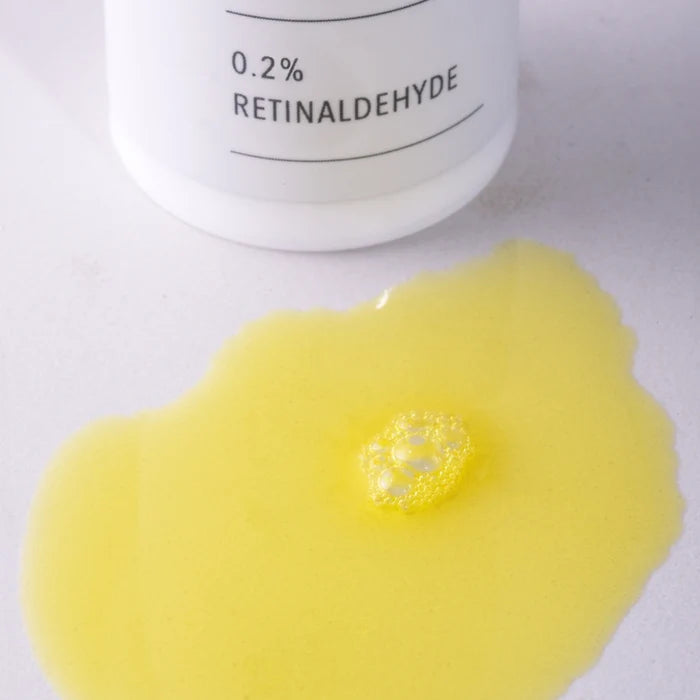 Yellow gel with a container labeled '0.2% Retinaldehyde' on a white background