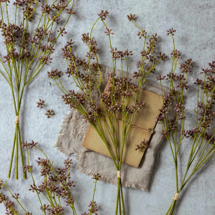 The ABIGAIL AHERN - BLUSH SUCCULENT BUNCH features small purple flowers and green stems tied with twine—a stylish artificial accent perfect for home decor. Add charm to any space with this unique piece from ABIGAIL AHERN.