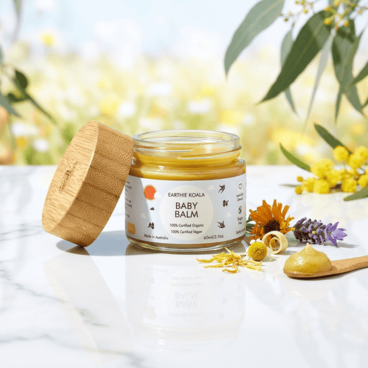 Baby Balm with Lavender and Orange Oil 60ml  - Earthie Koala in a jar with bamboo lid, surrounded by flowers and natural elements.