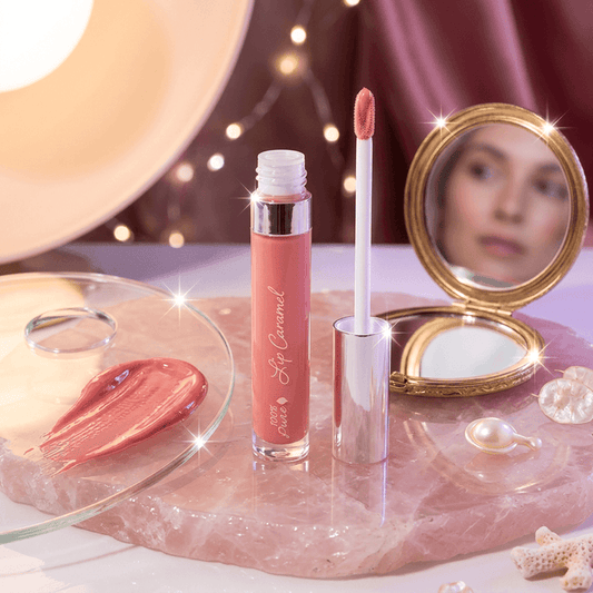 Lip gloss with applicator and mirror on a decorative surface