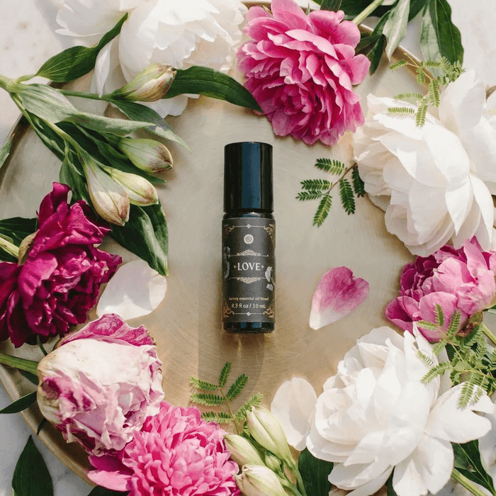 Love - Luxury Essential Oil Blend (10ml) - Annmarie Skin Care bottle surrounded by colorful flowers on a tray.
