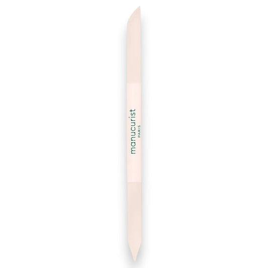 A light pink, double-ended MANUCURIST - GLASS CUTICLE PUSHER with “manucurist PARIS” printed in green at the center, displayed on a white background—an essential reusable nail tool from MANUCURIST INC for any manicure routine.