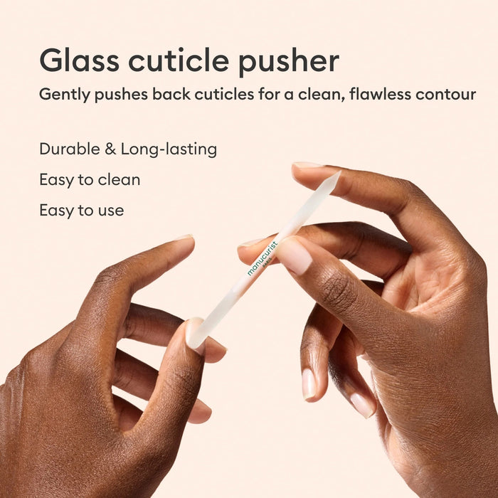 A light pink, double-ended MANUCURIST - GLASS CUTICLE PUSHER with “manucurist PARIS” printed in green at the center, displayed on a white background—an essential reusable nail tool from MANUCURIST INC for any manicure routine.