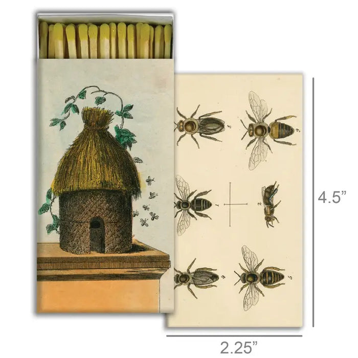 The HOMART MATCHES - HIVE & 6 BEES box features a straw beehive and bees on its cover, with vintage bee illustrations on the side. Ideal for lighting candles or as a charming collectible.