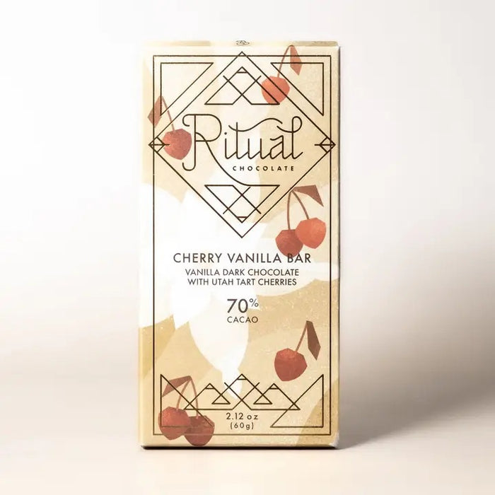 A beige RITUAL CHOCOLATE - CHERRY VANILLA DARK CHOCOLATE BAR 70% wrapper features geometric patterns, cherry art, and the text: "Vanilla Dark Chocolate with tart cherries, 70% Cacao, 2.12 oz (60g).