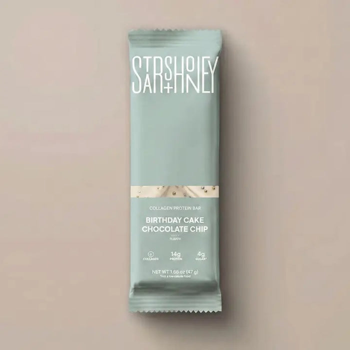 A wrapped STARS+HONEY - BIRTHDAY CAKE CHOCOLATE CHIP bar rests on a beige surface. The light blue packaging, branded with the STARS+HONEY logo and white text, displays nutrition details and hints at the irresistible flavors of vanilla yellowcake and natural sprinkles inside.