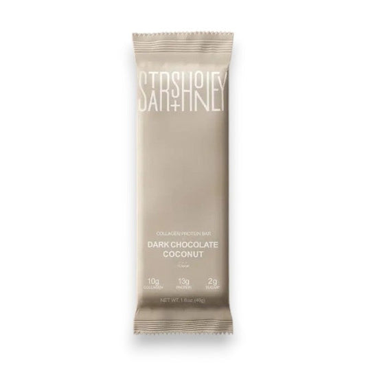 A STARS+HONEY - DARK CHOCOLATE COCONUT collagen protein bar is displayed on a coordinating beige background. The packaging emphasizes this low sugar protein bar from STARS+HONEY, highlighting that each bar contains 10g collagen, 13g protein, and only 2g sugar.