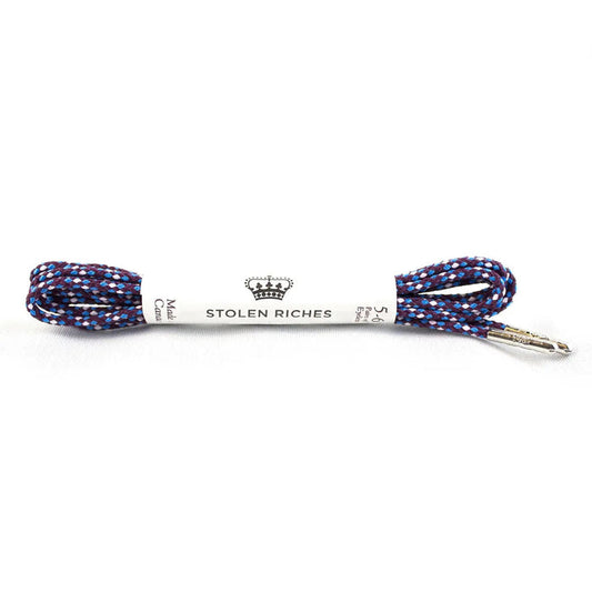 The STOLEN RICHES Dress Shoelace in Bavaria features a coiled blue, red, and white patterned premium nylon lace with silver tips and a branded white label—an eye-catching accessory for dress shoes.