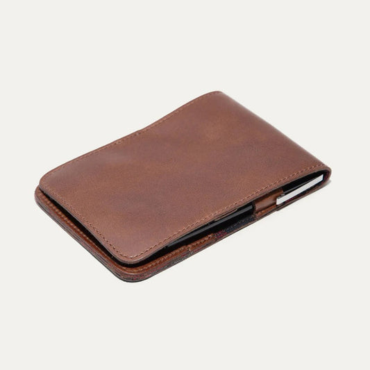 The WILL LEATHER GOODS GOLF YARDAGE BOOK IN COGNAC, by WILL LEATHER GOODS, features full-grain brown leather and a minimalist design—ideal for holding cards or a golf scorecard. It is shown closed on a plain white background.